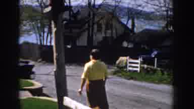 Michigan (1959): Woman Wearing A Yellow Shirt And Red Skirt Walking Down A