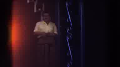Michigan (1959): Woman Wearing Yellow Shirt Waves At Camera On A Hazy Day