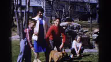 Michigan (1959): A Family And Their Dog Playing Around At Their Garden