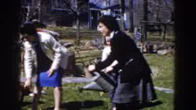 Michigan (1959): Woman Wearing Blue Dress Pets Brown Dog On A Sunny Day