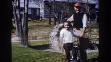 Michigan (1959): Brown Dog Jumps On Woman Wearing Blue Dress On A Sunny Day