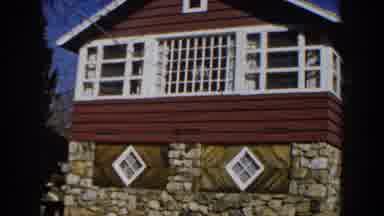 Michigan (1959): A View Of A House Made Of Rocks And Wood With White Windows