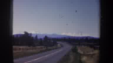Oregon (1957): View Of Snow Covered Mountains And Trees And Tan Field On A Sunny
