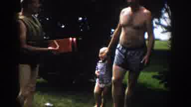 Wisconsin (1958): Man Wearing Blue Shorts Walks With Toddler Wearing Blue Shirt