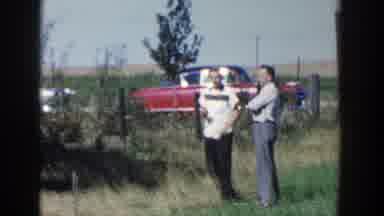 Wisconsin (1958): A Man Waves At Two Other Men Watching Him From A Distance