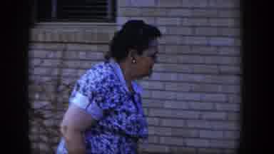 Las Vegas Nevada (1954): A Woman Observes A Flowering Plant Just Outside The