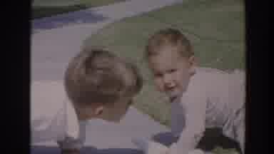 North Hollywood California (1964): Older Boy Looking On As Baby Boy Crawls Along