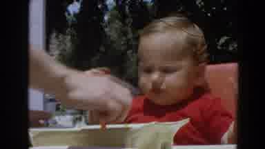 North Hollywood California (1964): Off Screen Person Feeds Toddler Wearing Red
