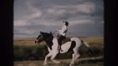 South Dakota (1953): Woman Wearing White Shirt Rides Black And White Horse Through