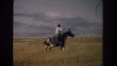 South Dakota (1953): Cowboy Riding His Black And White Horse In The Open Field