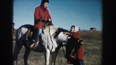 South Dakota (1953): A Man Rides A Horse While His Wife Attempts To Climb