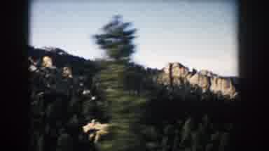 South Dakota (1953): Passing View Of Brown Mountains And Green Trees On A Sunny