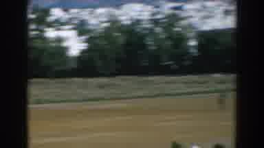 Greece (1962): Two Jockeys On Horses In A Race Buildings In Distance Beyond Track