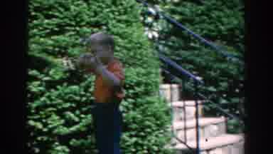 GREECE-1962: A Woman And Child Standing In Front Of Flower Bushes