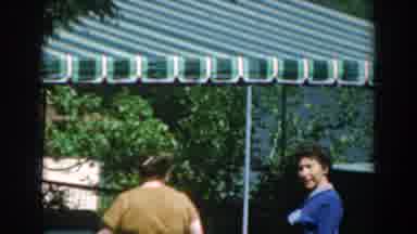 Greece (1962): A Pair Of Ladies Walking To An Green Awning Wearing A Blue Shirt