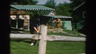GREECE-1962: Woman in Blue Shirt Gives Grey Object to Boy in Red Shirt