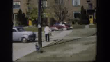 Nevada-1954: A Boy Swings On Playground Swing Near Vintage Cars And Apartment Building