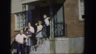 Nevada (1954): Five People Standing Near Red Brick House Wave At Camera On A