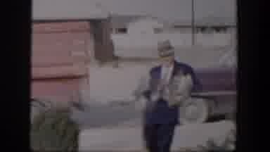 Nevada (1954): Old Man Wearing A Blue Suit And Top Hat Holding Several Items