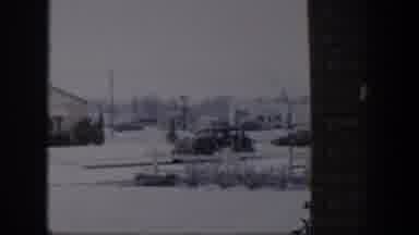 Nevada (1954): A Snowy Residential Landscape With Shrubbery Houses And Parked Cars