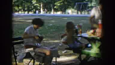 Nevada (1954): People Are Sitting And Cooking Food In Outdoor Area With Trees