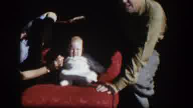 Nevada (1954): Parents Showing Their Baby Son Sitting On The Red Chair Mud