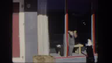 Nevada (1954): A Camera Pans Over A House While A Man Standing Inside Claps His