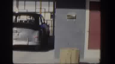 Nevada (1954): An Old Blue Car Is Show Next To A Brick Storefront With Large