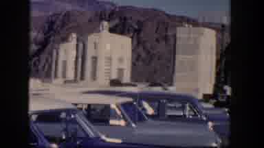 Nevada (1954): View Of Blue Cars Parked Near White Stone Pillars On A Sunny Day