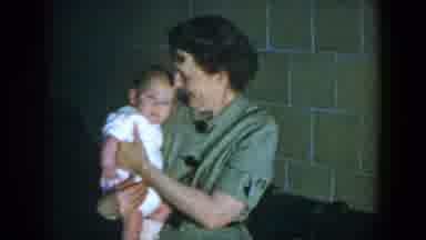 Houston Texas (1952): Woman Wearing Green Dress Holds Small Baby Wearing White