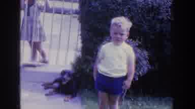 Ireland (1961): Small Boy In Shorts And Shirt Stands Inside A Gate While A Girl In
