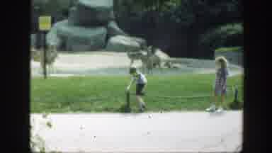 Washington DC (1948): Boy Wearing Black Shorts Steps Over Tan Rope On A Sunny Day