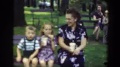 Washington DC (1948): A Woman And Two Young Children Relax On A Park Bench Sharing