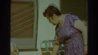 Puerto Rico (1966): A Woman Walks Opposite A Man Sitting On A Plastic Chair