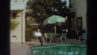 PUERTO RICO-1966: An Elderly Man Relaxes On A Plastic Chair Beside A Pool
