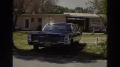 Puerto Rico (1966): View Of Dark Blue Car Parked Near White Motel Sign On A Sunny