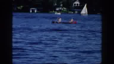 Brighton Michigan (1960): Two People Rowing Red Canoe In Blue Lake Water On A