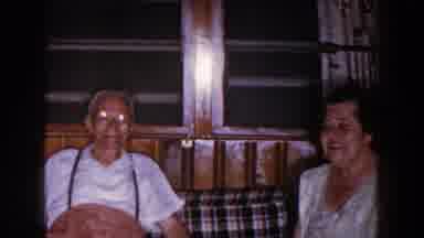 Brighton Michigan (1960): A Woman Interacts With Elder In Sunglasses Resting On A