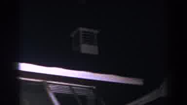 Brighton Michigan (1960): View Of Lightning Flashing Behind Brown And White Bell