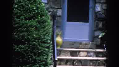 Brighton Michigan (1960): Camera Panning The Exterior Of A House With Bushes