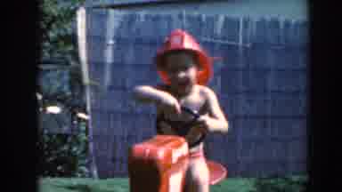 North Hollywood California (1961): A Boy Wearing A Red Hat Riding A Toy Motorbike