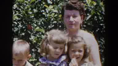 Lubbock Texas (1953): Woman Stands With Two Girls Near Green Hedge On A Bright