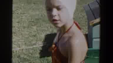 Lubbock Texas (1953): Child Wearing Swimsuit And White Cap Playing In Water In