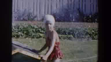 Lubbock Texas (1953): Girl Wearing A Red Swimsuit Is Riding Her Bike Outside On