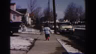 Dearborn Michigan (1961): A Little Boy Runs In A Lane Towards A Parked Car