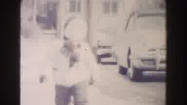 Dearborn Michigan (1961): Boy Wearing Light Blue Coat Stands Next To Wooden Door