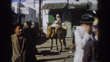 CASABLANCA-1959: People Walk Bike And Ride A Donkey On A Crowded Narrow