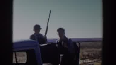 Lubbock Texas (1957): Two Hunters With One Holding A Gun Alight From A Car In