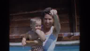 Van Nuys California (1962): Woman Wearing Blue Swimwear Waves At Camera While
