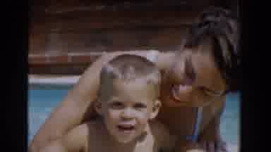 Van Nuys California (1962): Woman Wearing White Swimwear Helps Toddler Out Of Pool